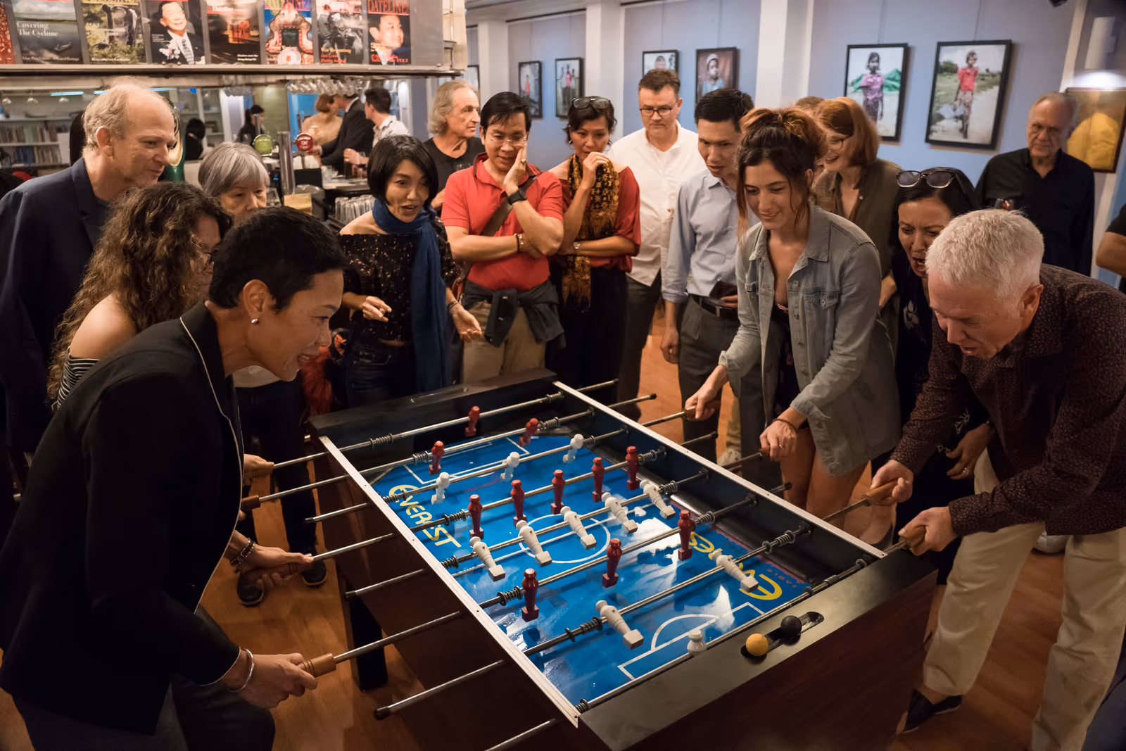 A crowd around the table-football table, playing and watching